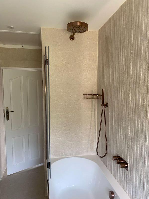 Bath with brushed bronze rainfall shower fittings