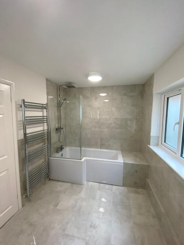 L-shaped bath with shower screen and chrome towel rail